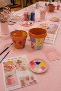 Pot en terre cuite en cours de décoration avec peinture colorée et ficelle naturelle, atelier créatif